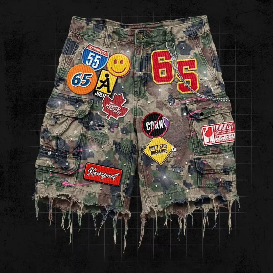 Camouflage shorts with various patches on a dark background